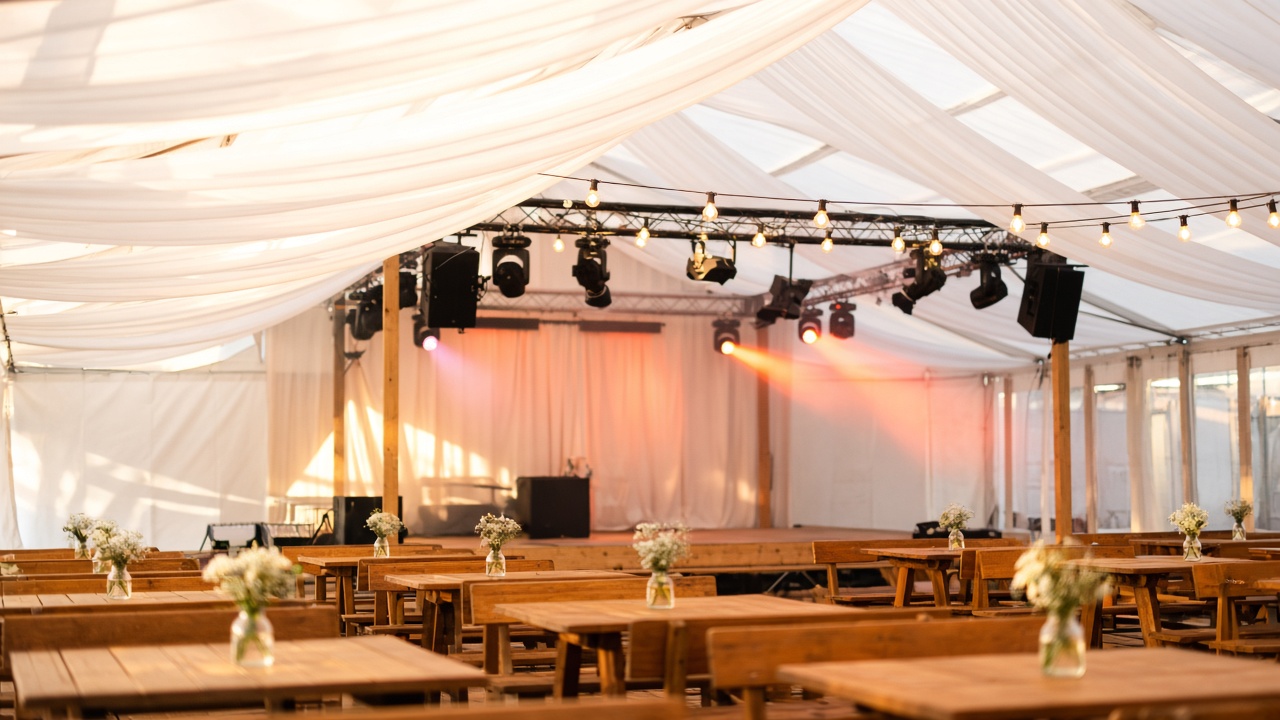 Festzelt-Dorfparty mit warmem Bühnenlicht und Traversen